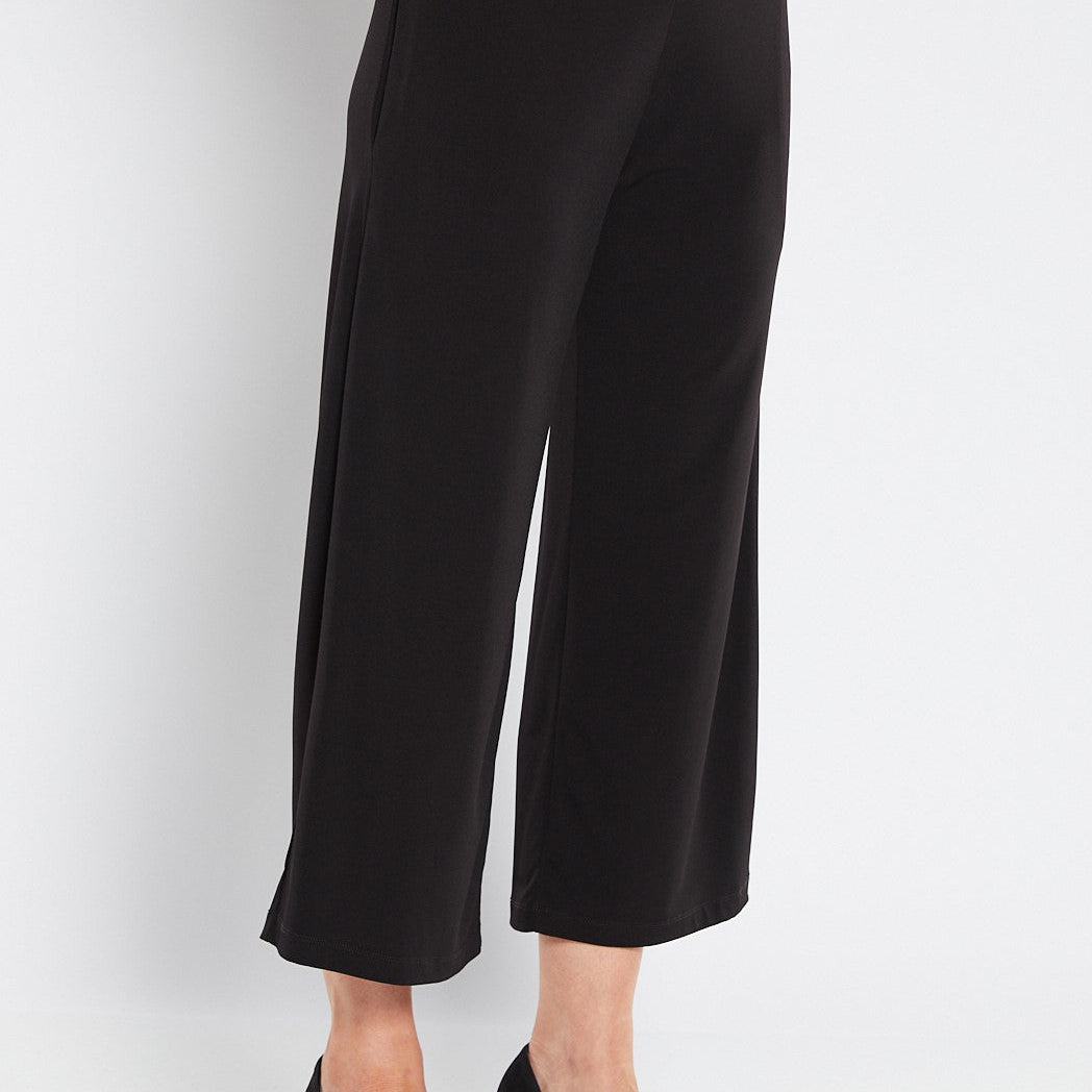 Black wide-leg pants worn by a person on a white background