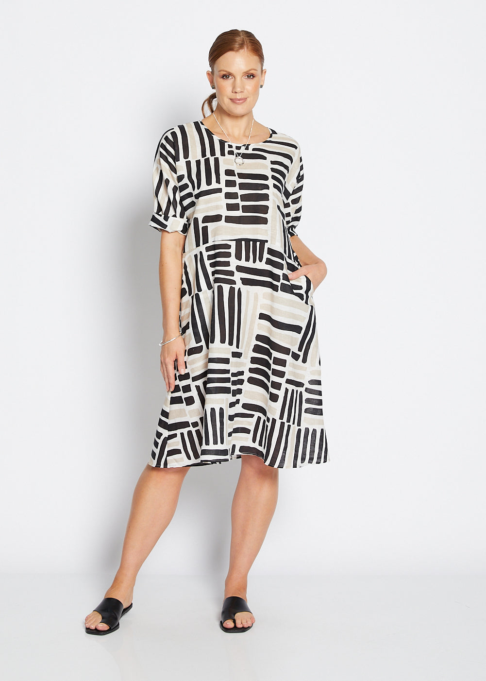 Woman wearing a black and white patterned dress on a white background