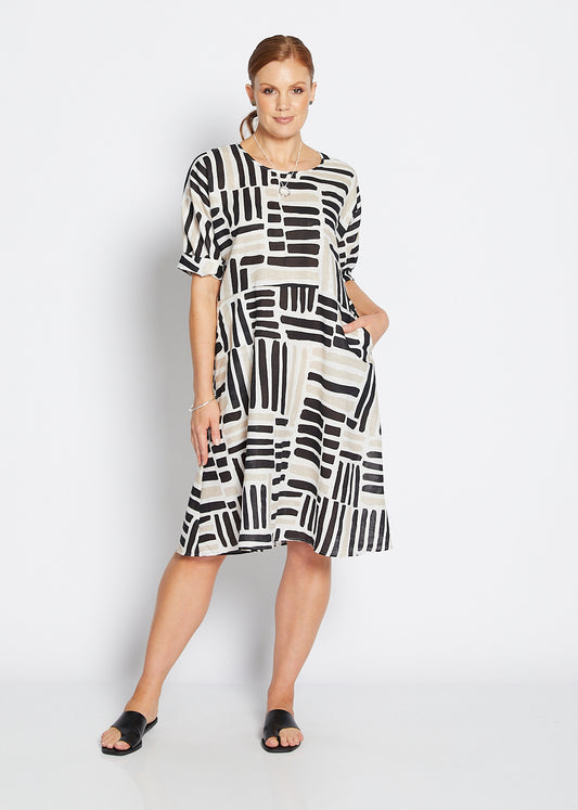 Woman wearing a black and white patterned dress on a white background