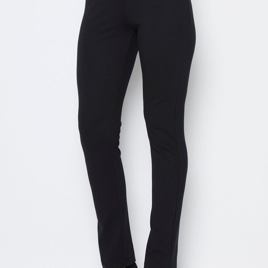 A model wearing black full length straight leg ponte pants with an elastic waistband.