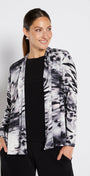 Woman wearing a patterned jacket over a black top on a white background