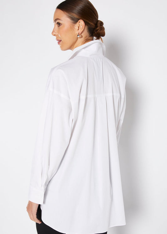 Woman wearing a white shirt against a plain background