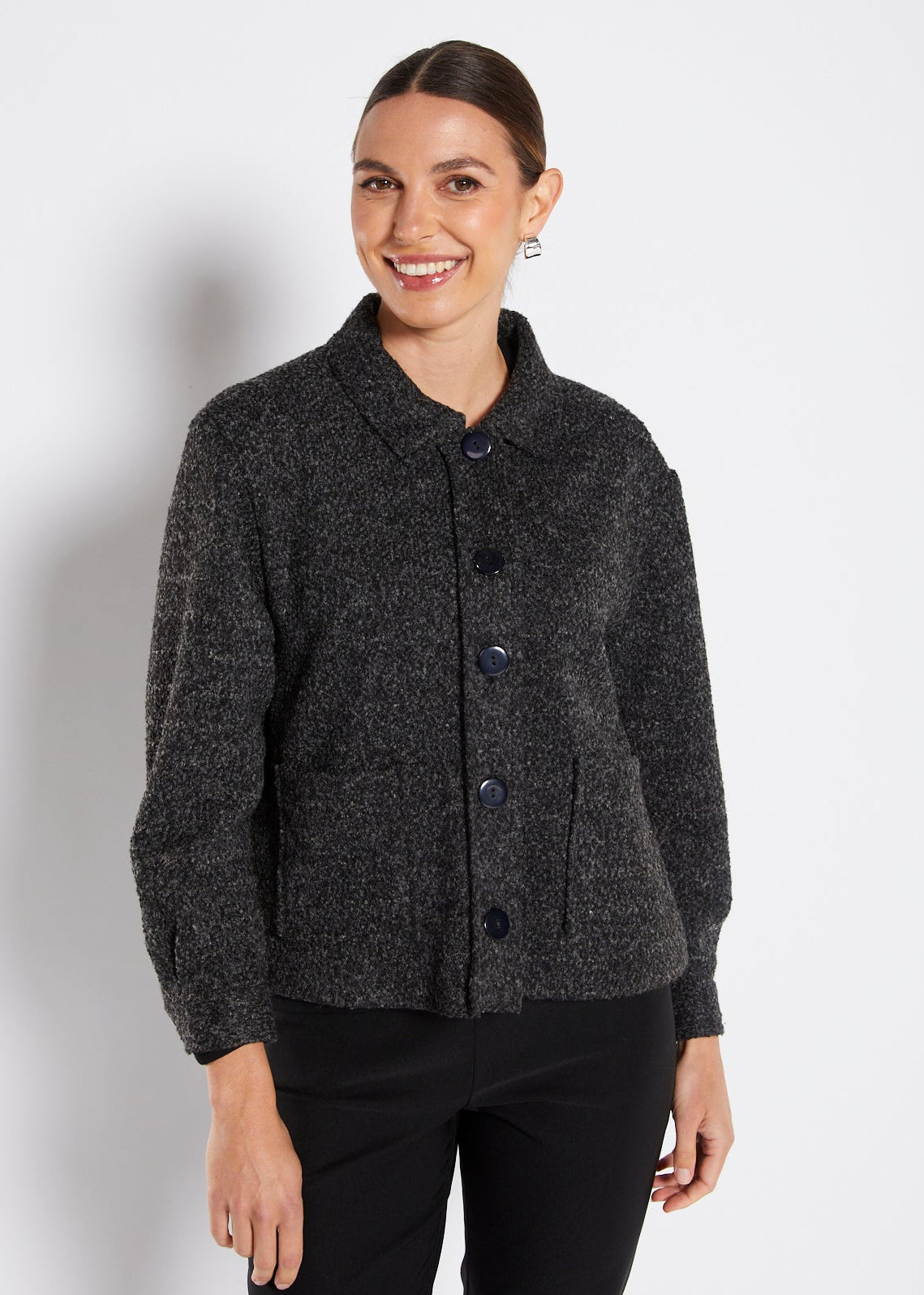 Woman wearing a dark gray cardigan on a white background
