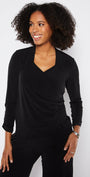 Woman wearing a black long-sleeve top against a white background