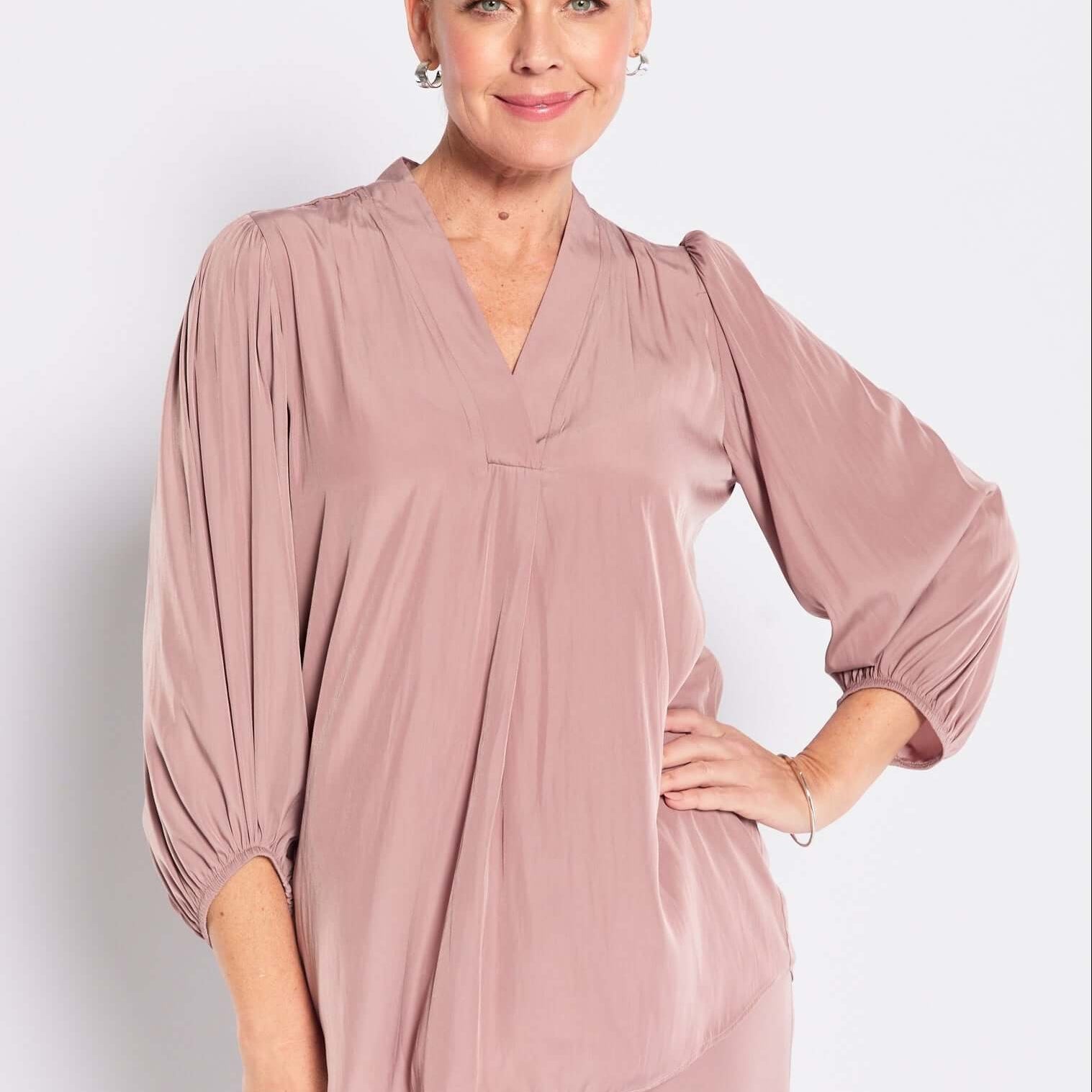 Woman wearing a mocha outfit against a white background