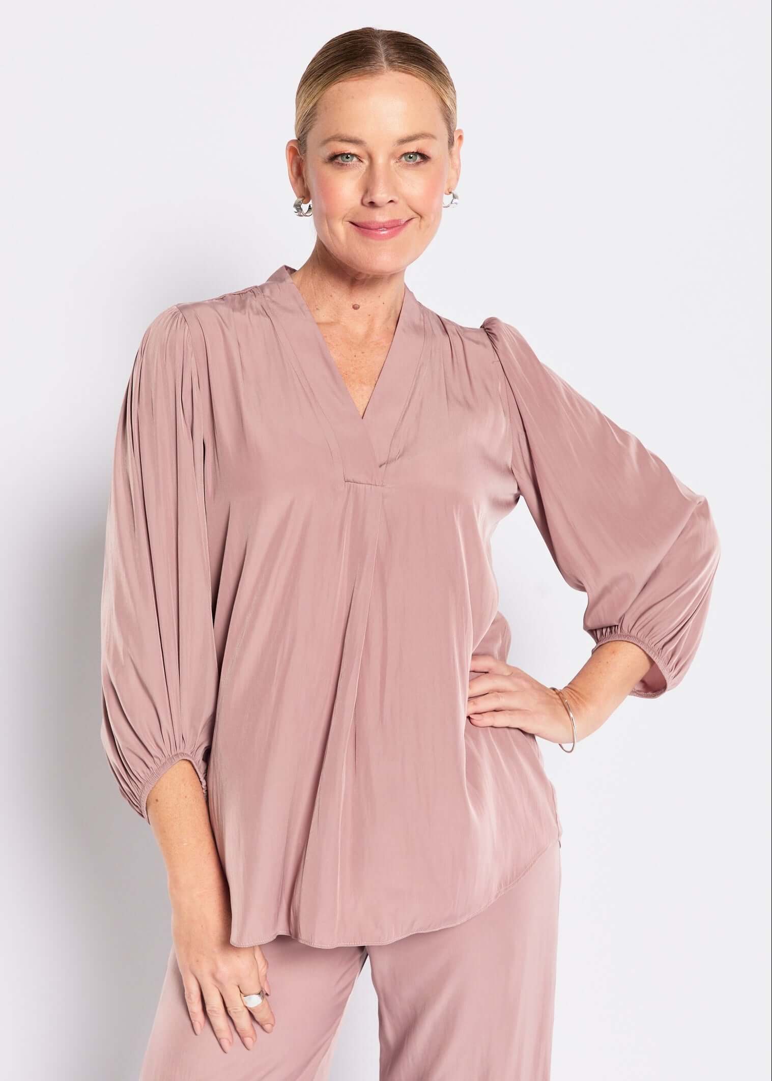 Woman wearing a mocha outfit against a white background