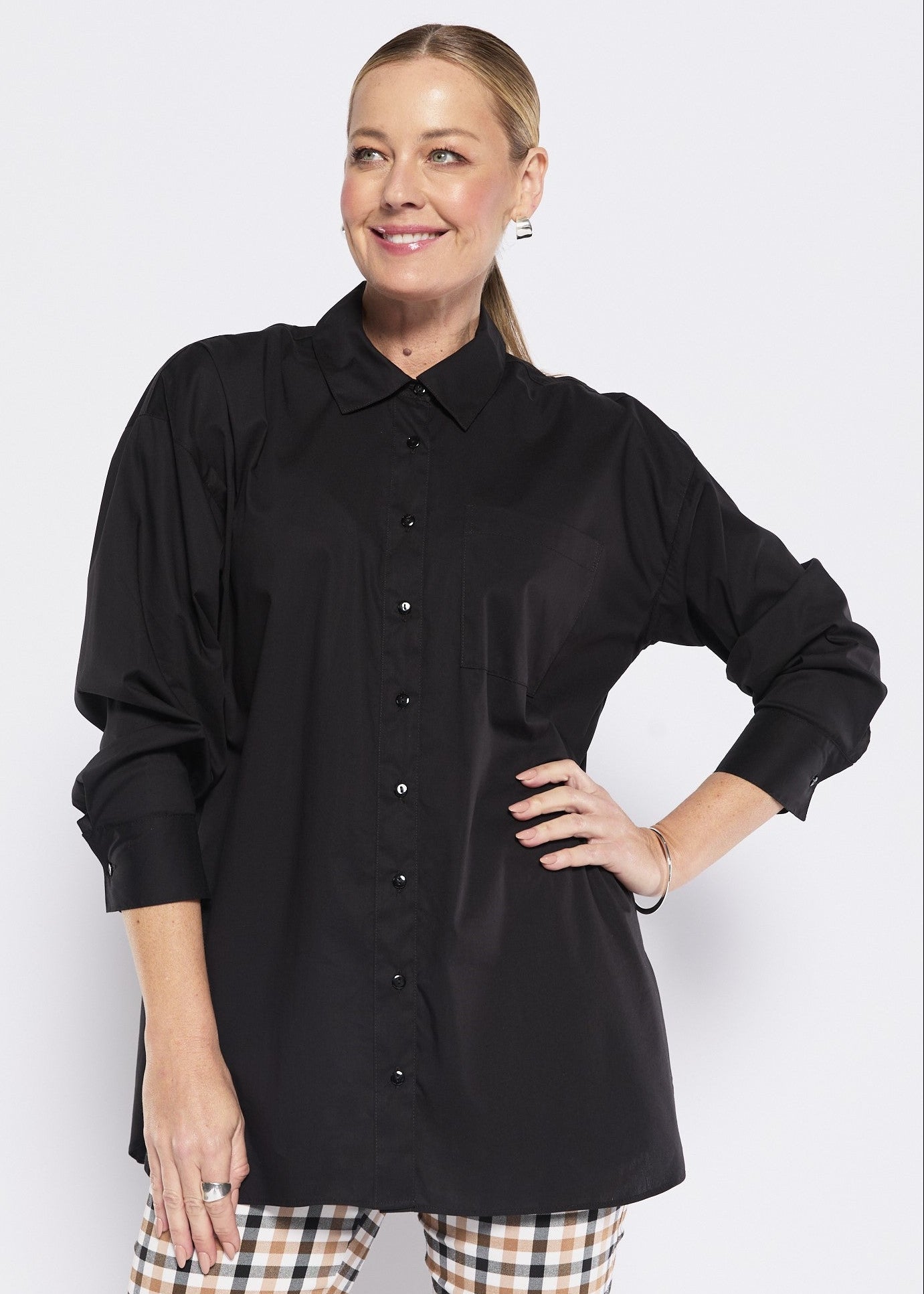 Woman wearing a black shirt and plaid pants on a white background