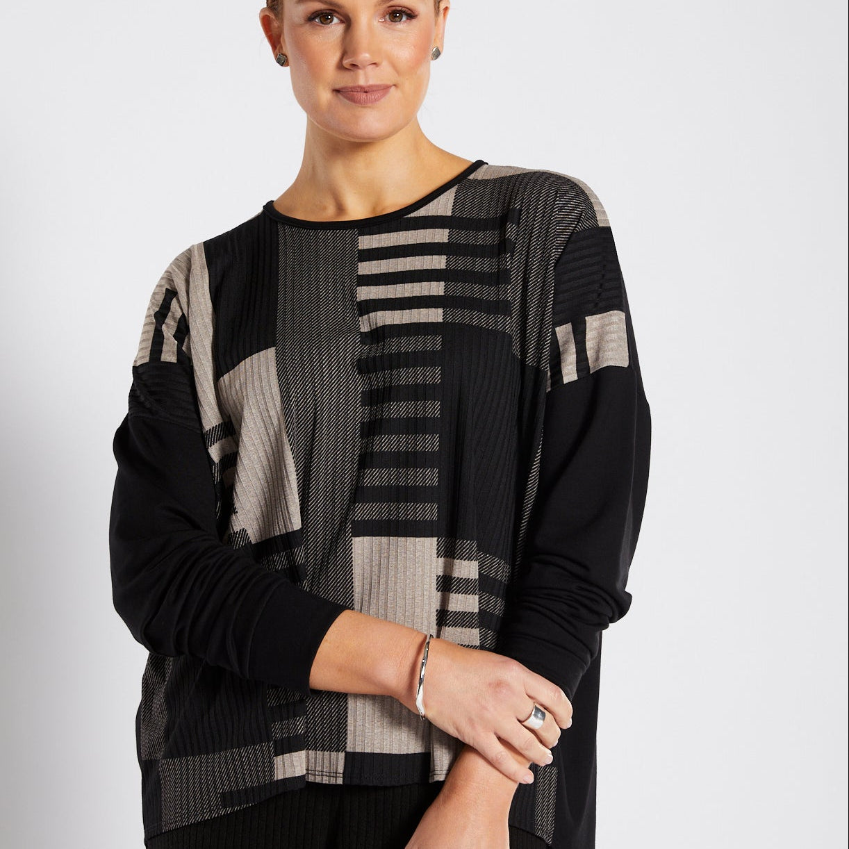 Woman wearing a black and gray patterned outfit on a white background