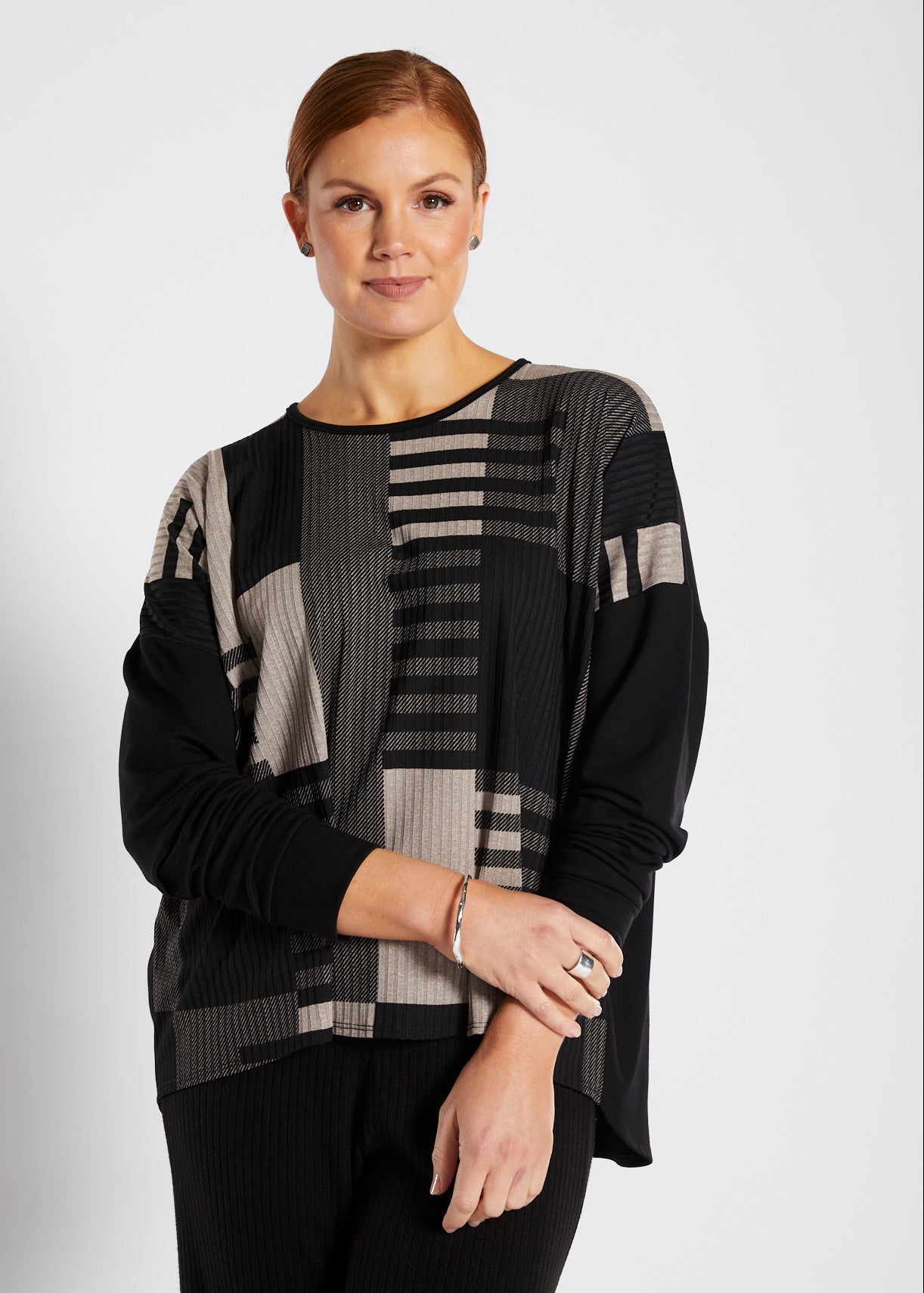 Woman wearing a black and gray patterned outfit on a white background