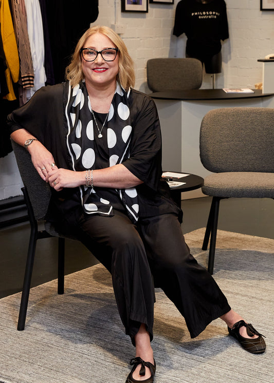 Woman sitting on a chair in a clothing store