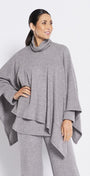 Woman wearing a gray outfit with a poncho-style top and wide-leg pants on a white background