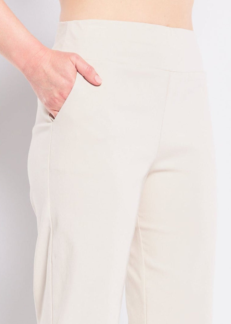 Person wearing white pants and black shoes on a plain background